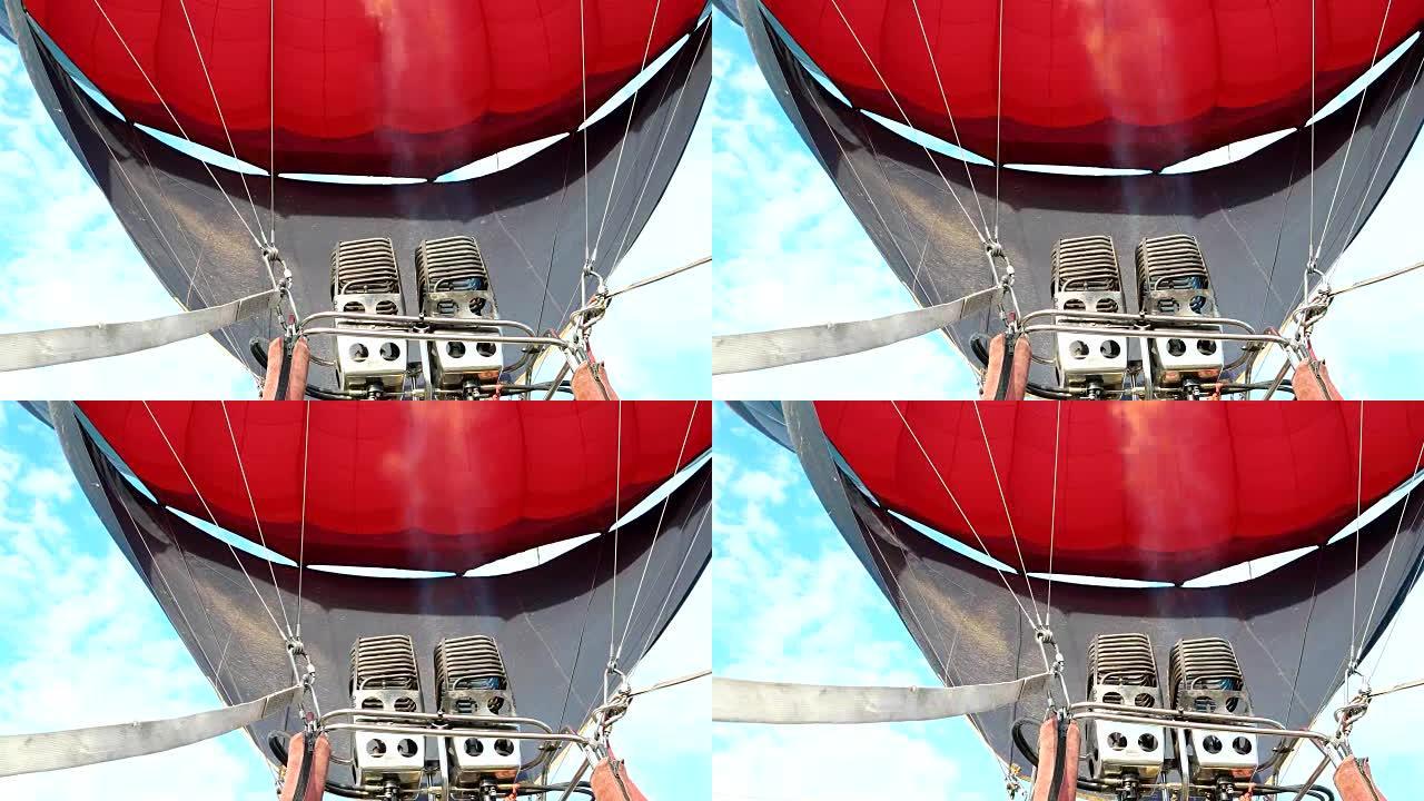 大型燃气燃烧器用热空气向气球充气，使其升至地面上方。巨大的气球在空中飞行，旅游娱乐，气球。燃气燃烧器