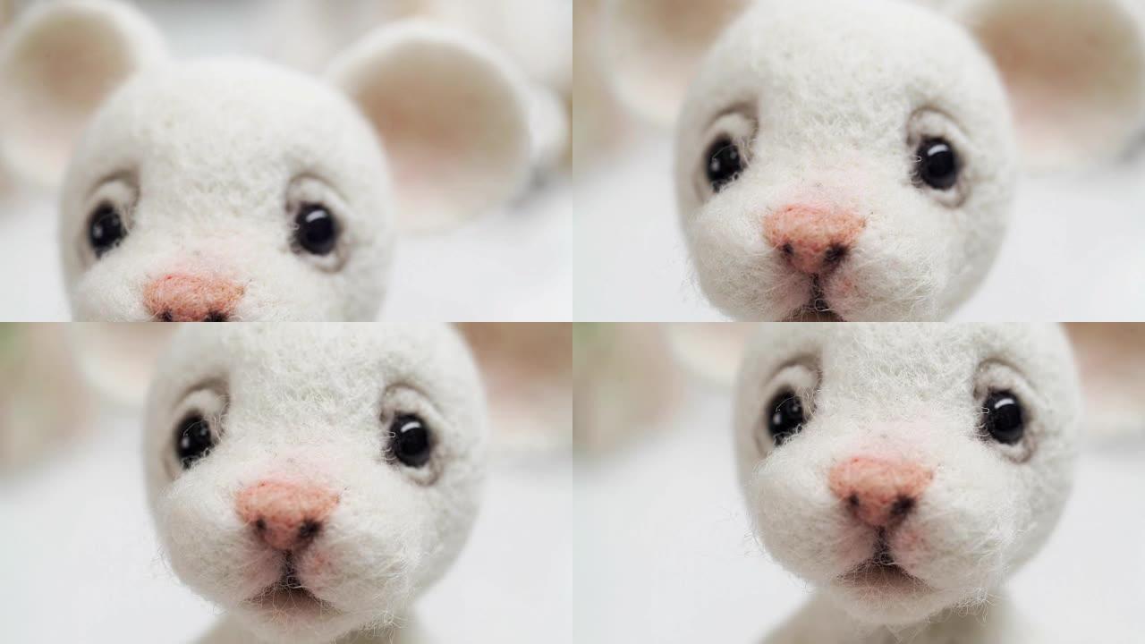 毛毡手工制作的毛绒玩具: 带有悲伤的眼睛和粉红色nos的白色兔子
