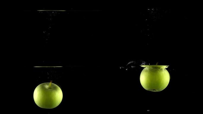 绿色苹果在黑色背景下落水，超级慢动作