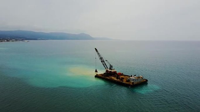 驳船用钢包从海底提起沙子。无人机的风景照片。地中海。塞浦路斯