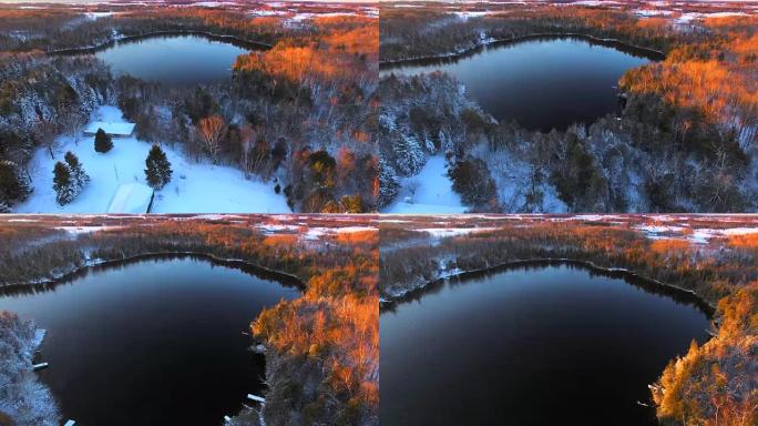 黎明时分，冰雪覆盖的树林环绕着冰冷的湖泊