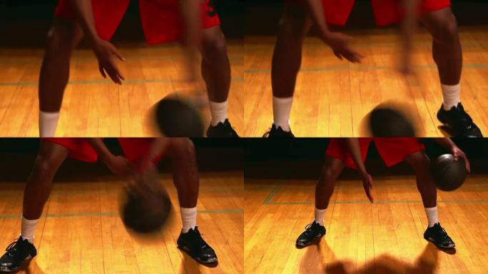 一名篮球运动员在黑色背景下在两腿之间运球，近距离