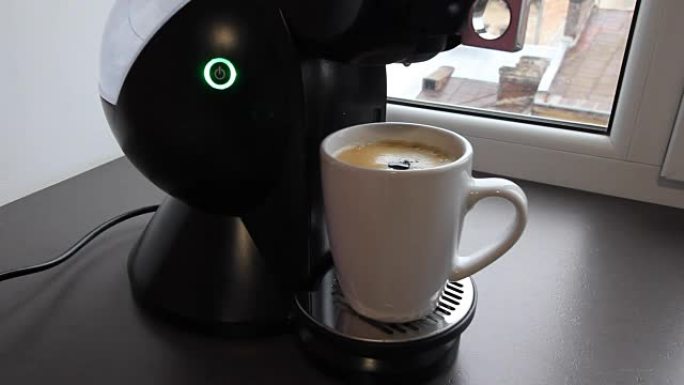 一滴新鲜咖啡掉进了杯子里。咖啡机已经完成了早上的咖啡制作