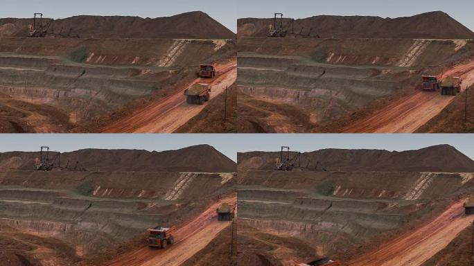 自卸卡车从采石场运出矿石。矿井全景图。新月形沙丘砂。矿产资源的开发。