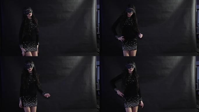 戴面具的女孩在黑色背景上跳舞