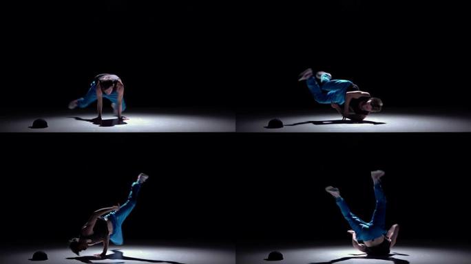 穿着蓝色裤子的舞者手上跳霹雳舞，黑色，阴影，慢动作