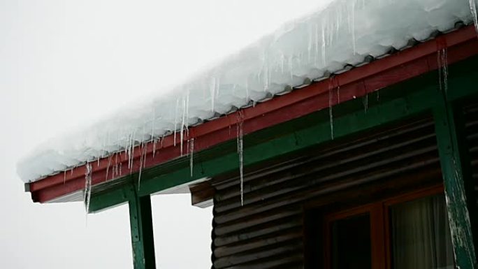 木制小屋上的冰柱融化