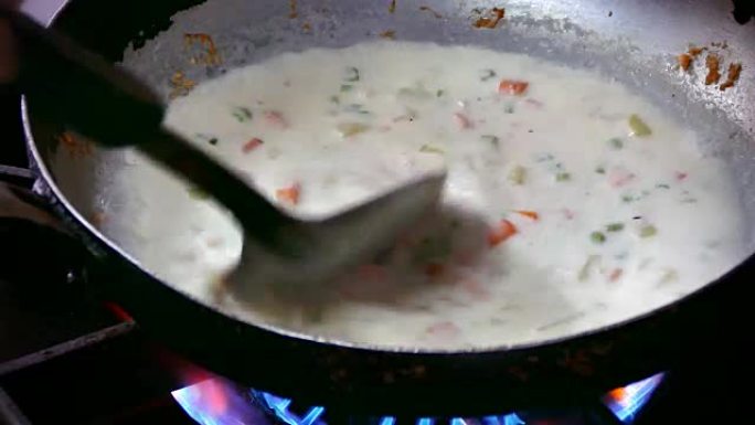 4k镜头，厨师在煎锅中用鲑鱼，奶油和欧芹煮鱼汤