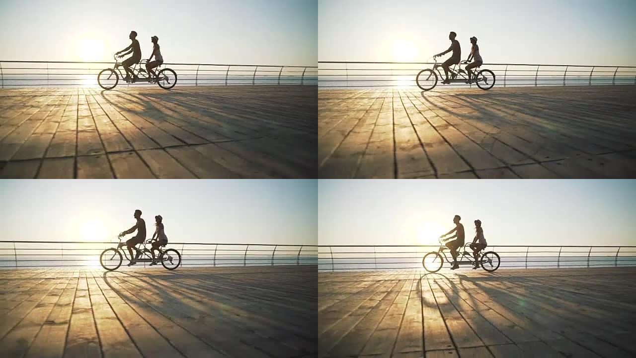 混血夫妇在海边户外双人自行车骑行的肖像，慢动作