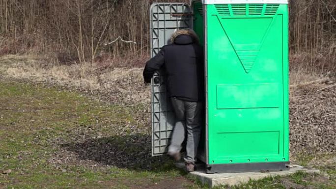 男人去绿色便携式厕所