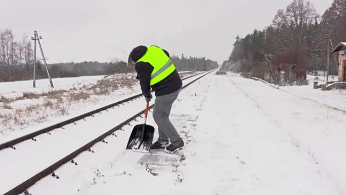 铁路员工清理铁路附近的积雪并走开