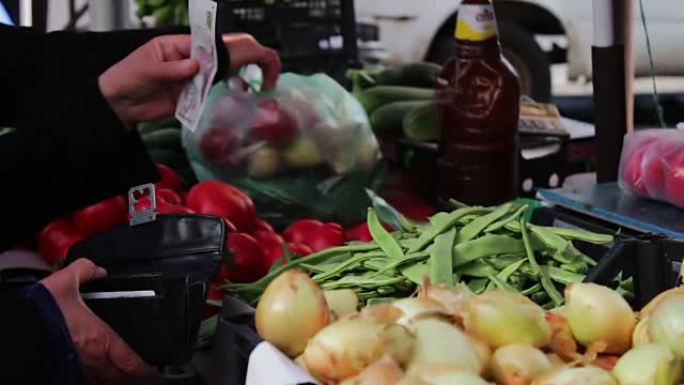 市场柜台上有很多新鲜蔬菜。买家会选择新鲜的西红柿，土豆，辣椒，豆类，樱桃，香蕉。市场上的买方和卖方。