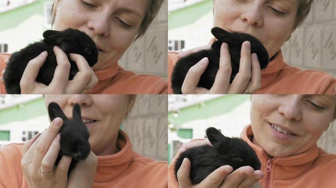 女孩抱着和宠物小黑兔宝宝
