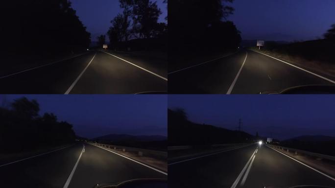 在漆黑的夜晚在乡村道路上行驶，大灯打开，pov