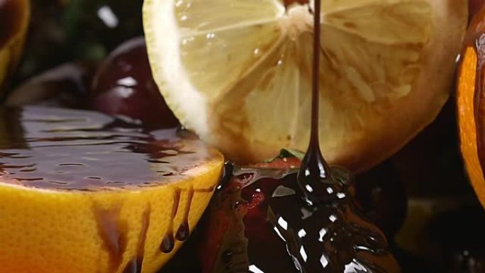 慢动作将巧克力糖浆倒在装有水果的盘子上
