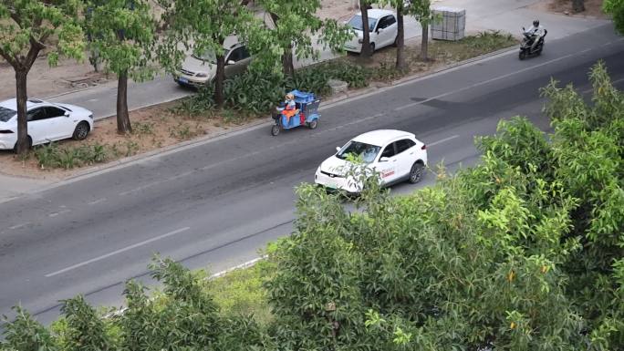 行驶在马路上的白色新能源共享汽车滴滴打车