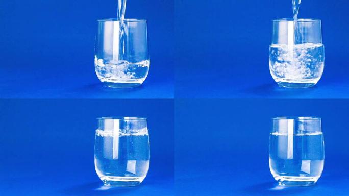 在蓝色背景上注满水的玻璃杯