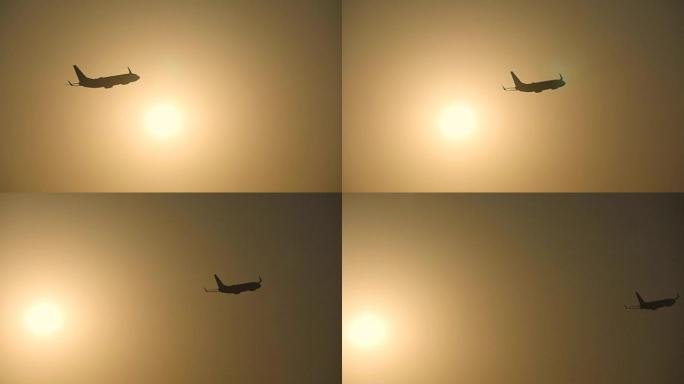 日落时，客机的轮廓飞过太阳。飞机在日出背景下起飞。飞机在美丽的早晨天空穿越sunrais。慢动作特写