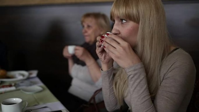 餐桌上的咖啡吧里的女人在喝一杯美酒