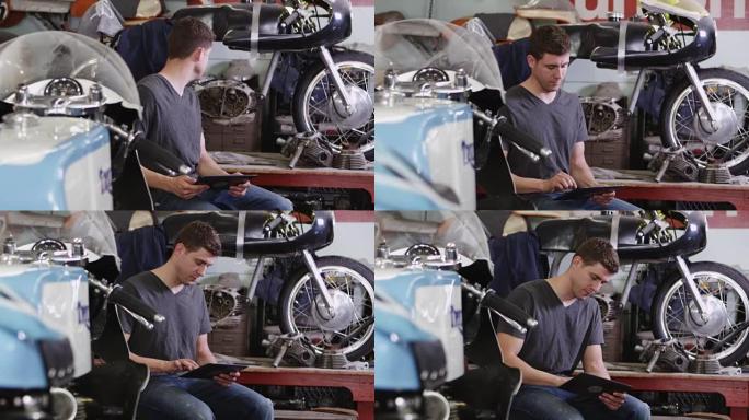 男子在摩托车附近使用平板电脑