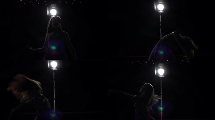 女孩芭蕾舞演员长发在黑暗中跳舞。