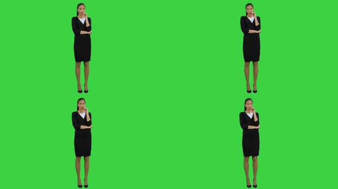 忧心忡忡的女商人咬着指甲，看着绿色屏幕上的侧面，色度键