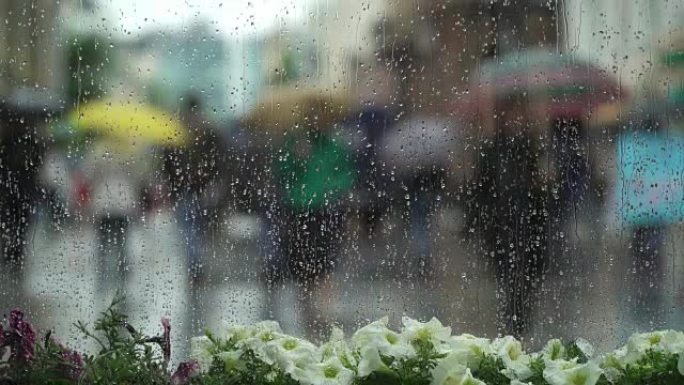 在城市街道的雨天，透过白花的窗户可以看到抽象的美丽背景。窗户玻璃上的雨滴。模糊的波克。自然背景