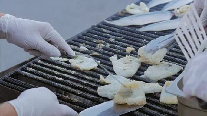 厨师在开放式烤架上煎鱼，拉班和鱿鱼。在烤肉店烹饪鲭鱼鱼片