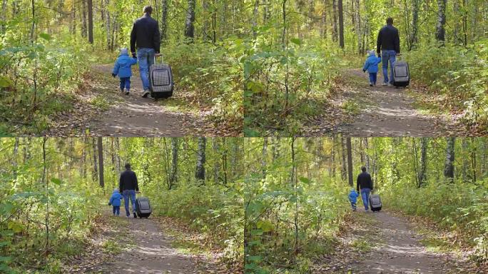 男人和孩子带着手提箱在森林小径上行走