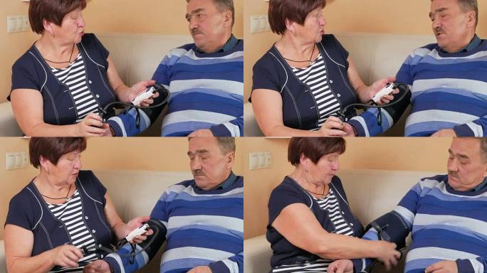 老年妇女在沙发上测量家里的血压。穷人的幸福。照顾妻子的丈夫