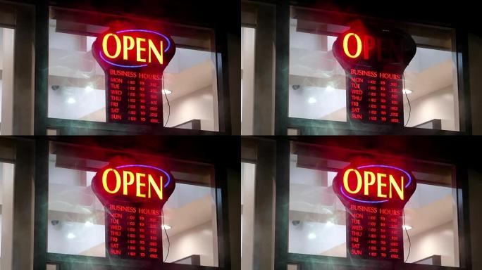 商业商店开放标志在下雨的夜晚打开和关闭前窗