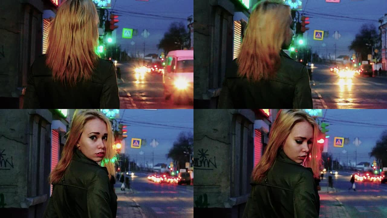 年轻的金发女人在夜晚的街道上回望色调的镜头