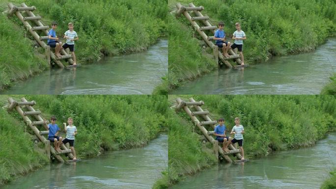 两个小男孩玩得开心，把石头扔进河里。