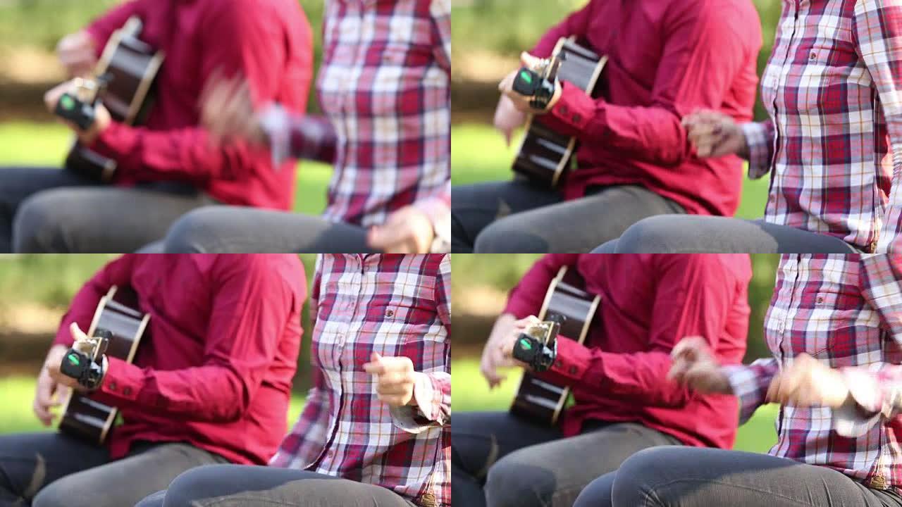 男人弹吉他和女人弹指的特写镜头
