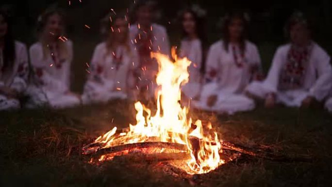 仲夏之夜。穿着斯拉夫衣服的年轻人坐在篝火旁。