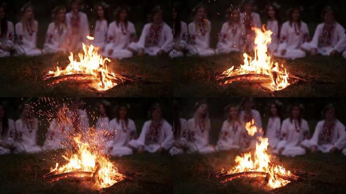 仲夏之夜。穿着斯拉夫衣服的年轻人坐在篝火旁。