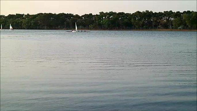 曼谷周日晚上，许多人在公园湖上享受帆船和皮划艇
