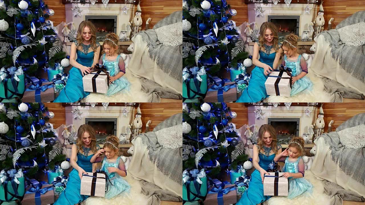 可爱的小女孩，有妈妈的样子，打开了一份圣诞礼物，精美地装在带蝴蝶结的包装纸盒里，圣诞树下有礼物，家人