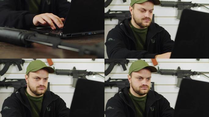 一个年轻人正在用一台笔记本电脑工作，接下来是一把枪