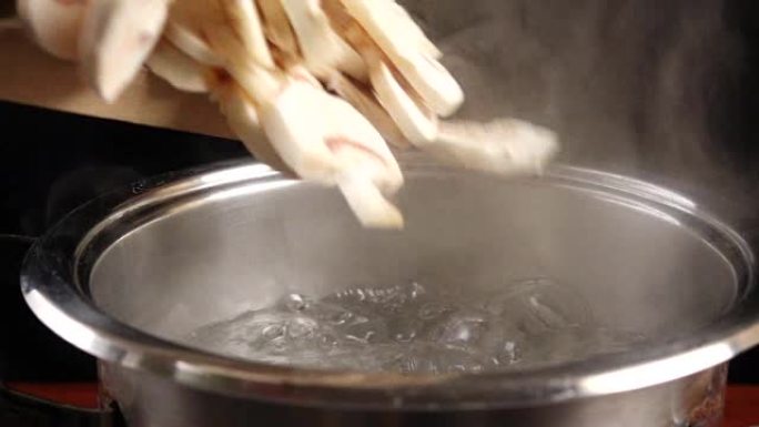 在沸水中掉落切成薄片的蘑菇，慢动作