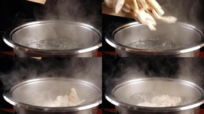 在沸水中掉落切成薄片的蘑菇，慢动作
