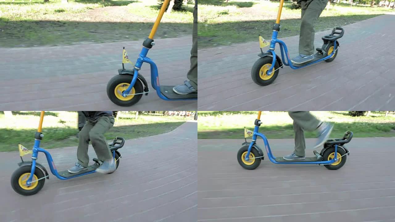 儿童在夏季公园快速骑推踢踏板车