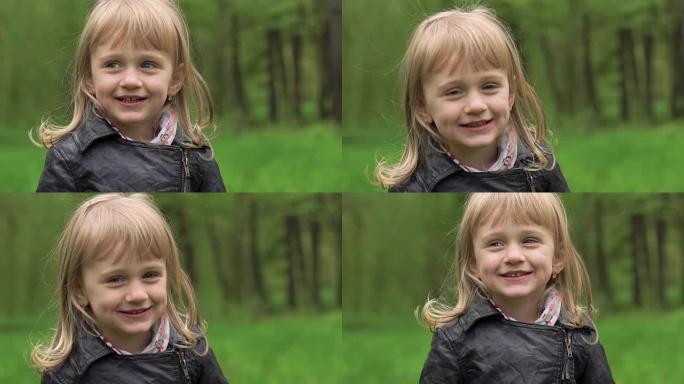 可爱的金发小女孩在公园里微笑。慢慢地