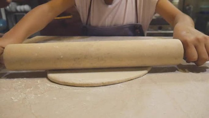 亚洲儿童学习厨师制作披萨