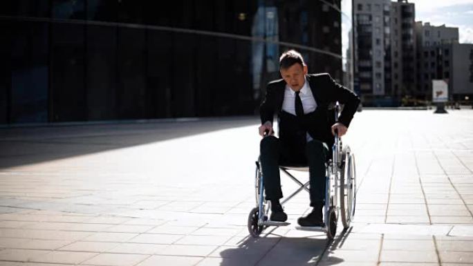 残疾商人试图从外面的轮椅上站起来