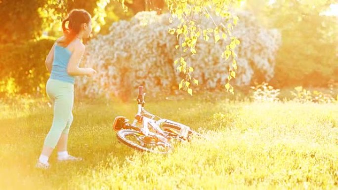 快乐的小女孩在阳光明媚的日子在草地上跳舞。