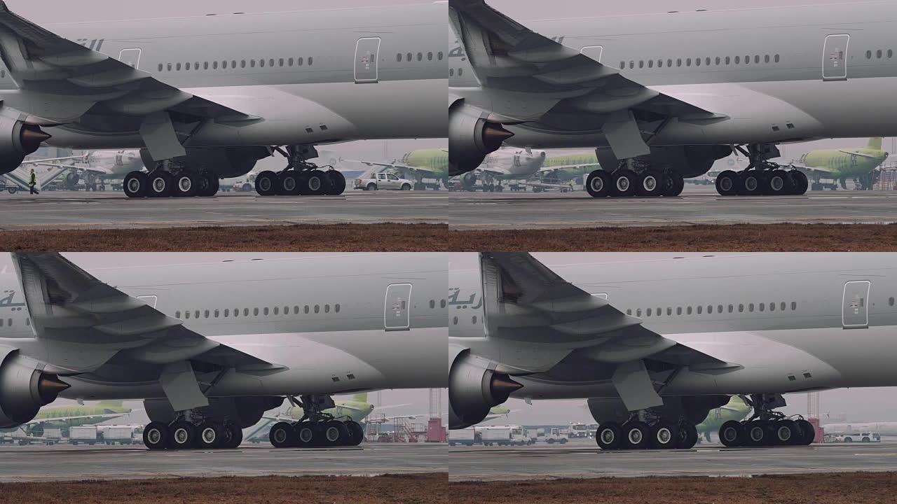 777的300ER波音的轮子和涡轮机在机场的跑道上移动。特写镜头，雾天气