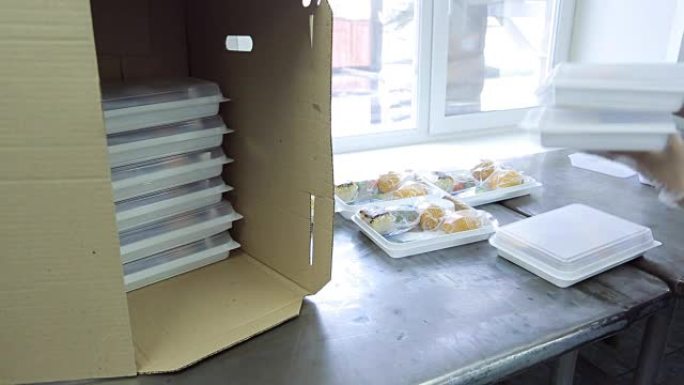 航空公司餐饮设施的一名员工将食物托盘放在盒子里
