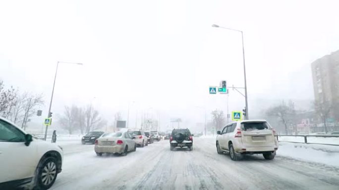 在雪道上驾驶POV。暴风雪驾驶城市街道快速延时。冬季暴风雪袭击。在积雪和结冰的道路上危险的驾驶条件。