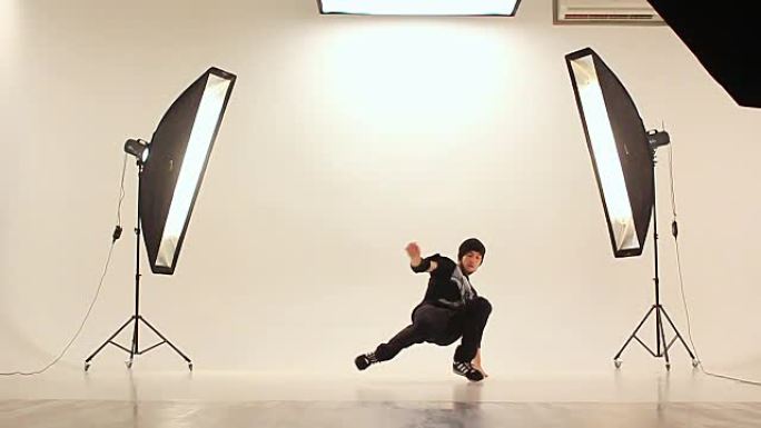 B-boy在白色背景的照相馆里跳霹雳舞